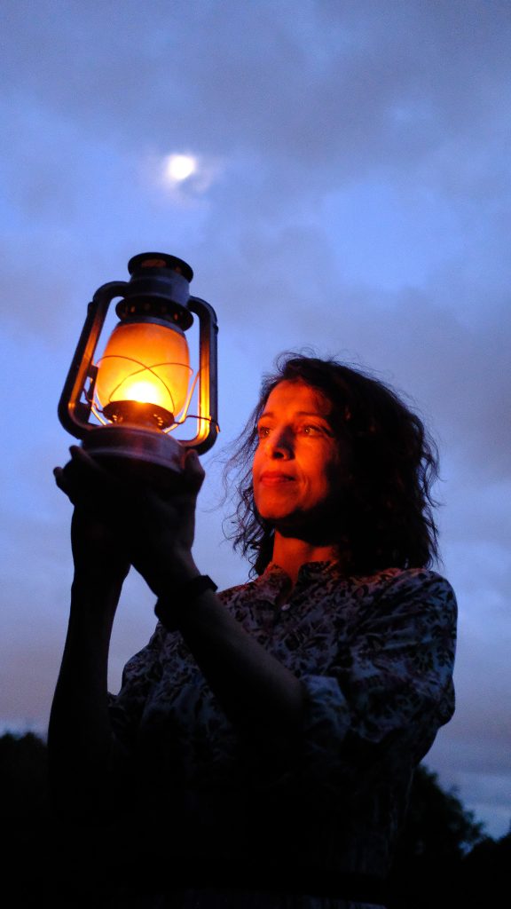 vanessa holding a lantern to her face